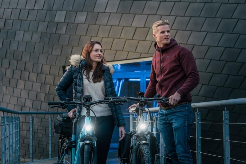 Zwei Personen auf ihren Fahrrädern, mit Frontlicht.
